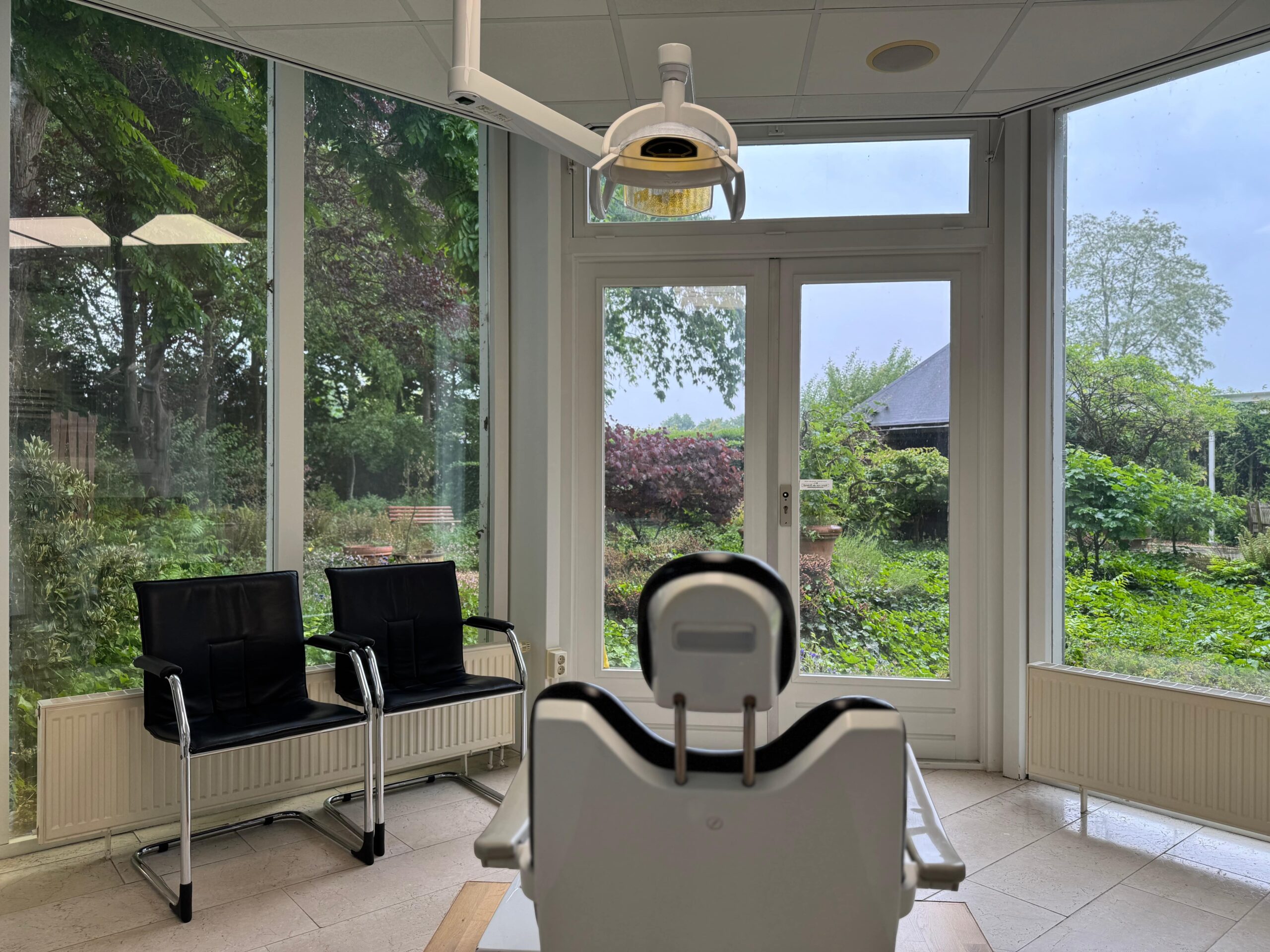 Behandelkamer met grote ramen in tandartsenpraktijk Nelemans Jeucken.